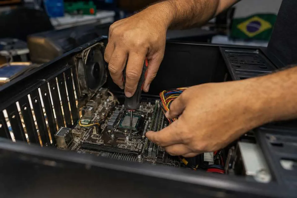 Técnico consertando um computador desktop aberto em bancada de assistência técnica em Vila Leopoldina